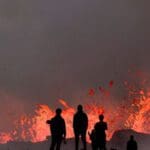 வெடித்துச் சிதறும் எரிமலை: அருகே செல்லும் சுற்றுலாப்பயணிகள்