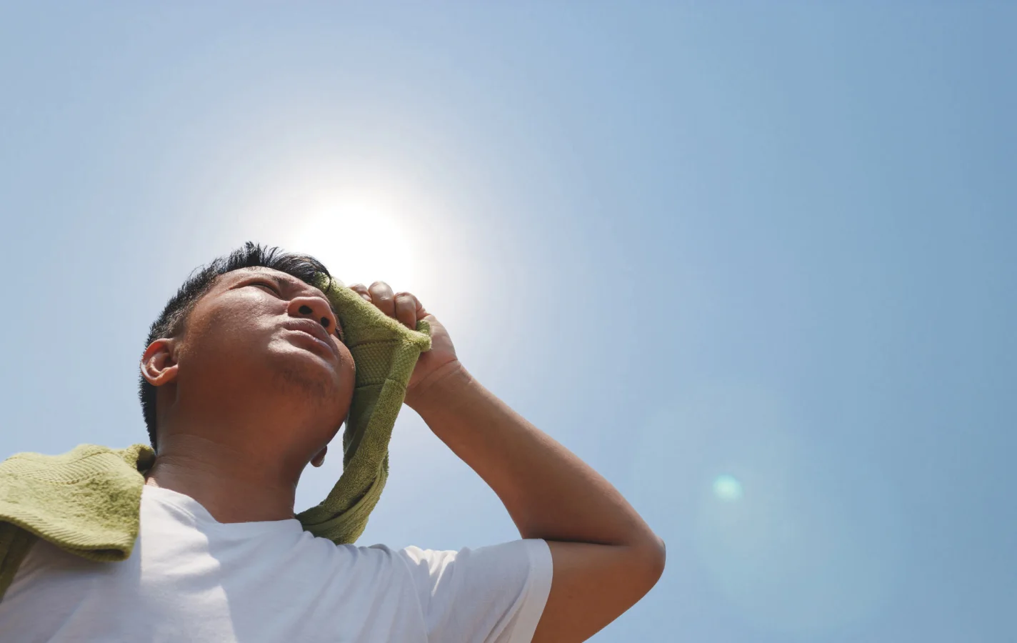 உடல் சூட்டை தணிக்க வேண்டுமா? இதோ சில வழிகள் 1 man wiping his forehead in the hot summer sun